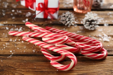Photo of Sweet Christmas candy canes on wooden table, closeup