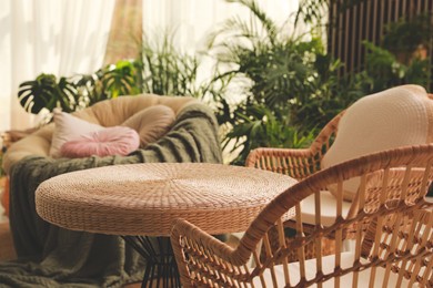 Photo of Indoor terrace interior with wicker furniture and green plants