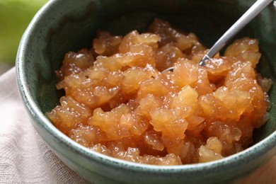 Photo of Bowl with delicious apple jam on table, closeup