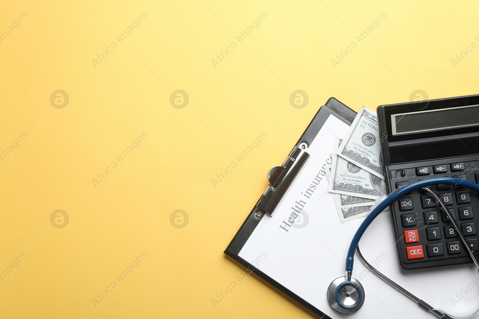Photo of Flat lay composition with medical insurance form, money, stethoscope and calculator on yellow background. Space for text
