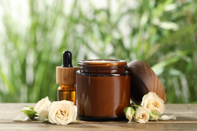 Photo of Different hand care cosmetic products and roses on wooden table