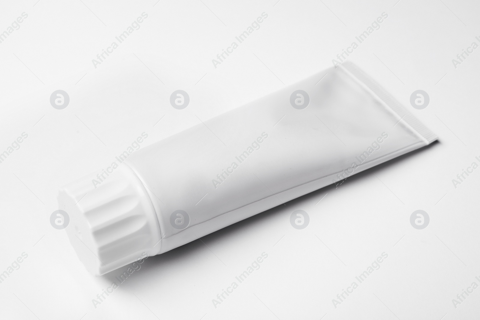 Photo of Blank tube of toothpaste on white background