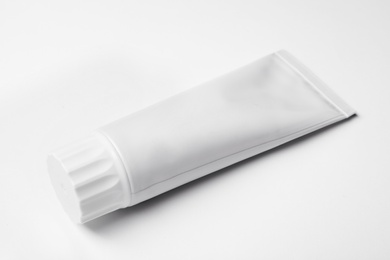 Photo of Blank tube of toothpaste on white background