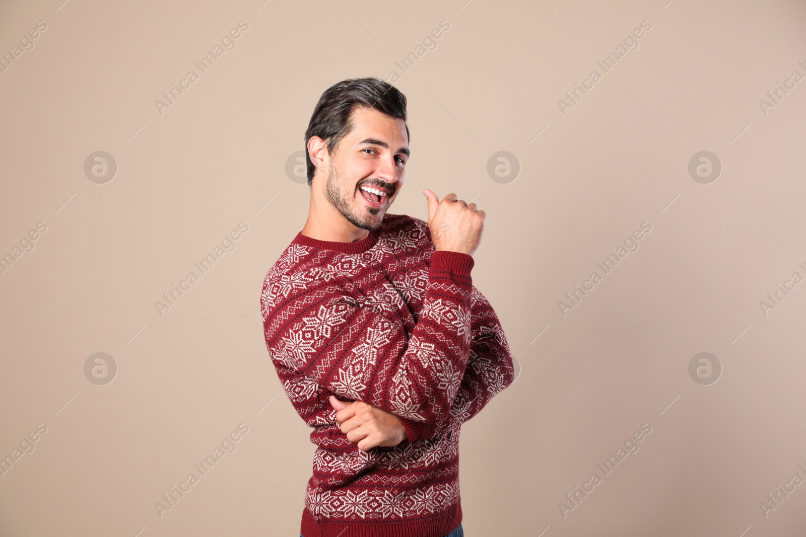 Photo of Portrait of happy man in Christmas sweater on beige background