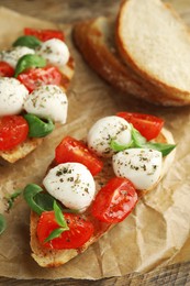 Delicious sandwiches with mozzarella, fresh tomatoes and basil on parchment