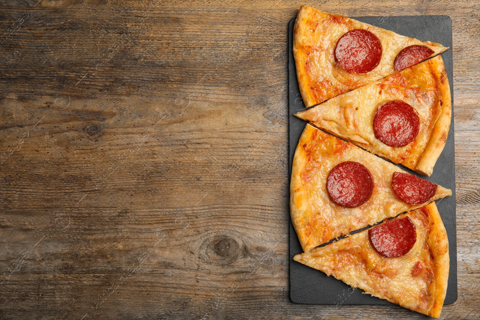 Photo of Tasty pepperoni pizza on wooden table, top view. Space for text