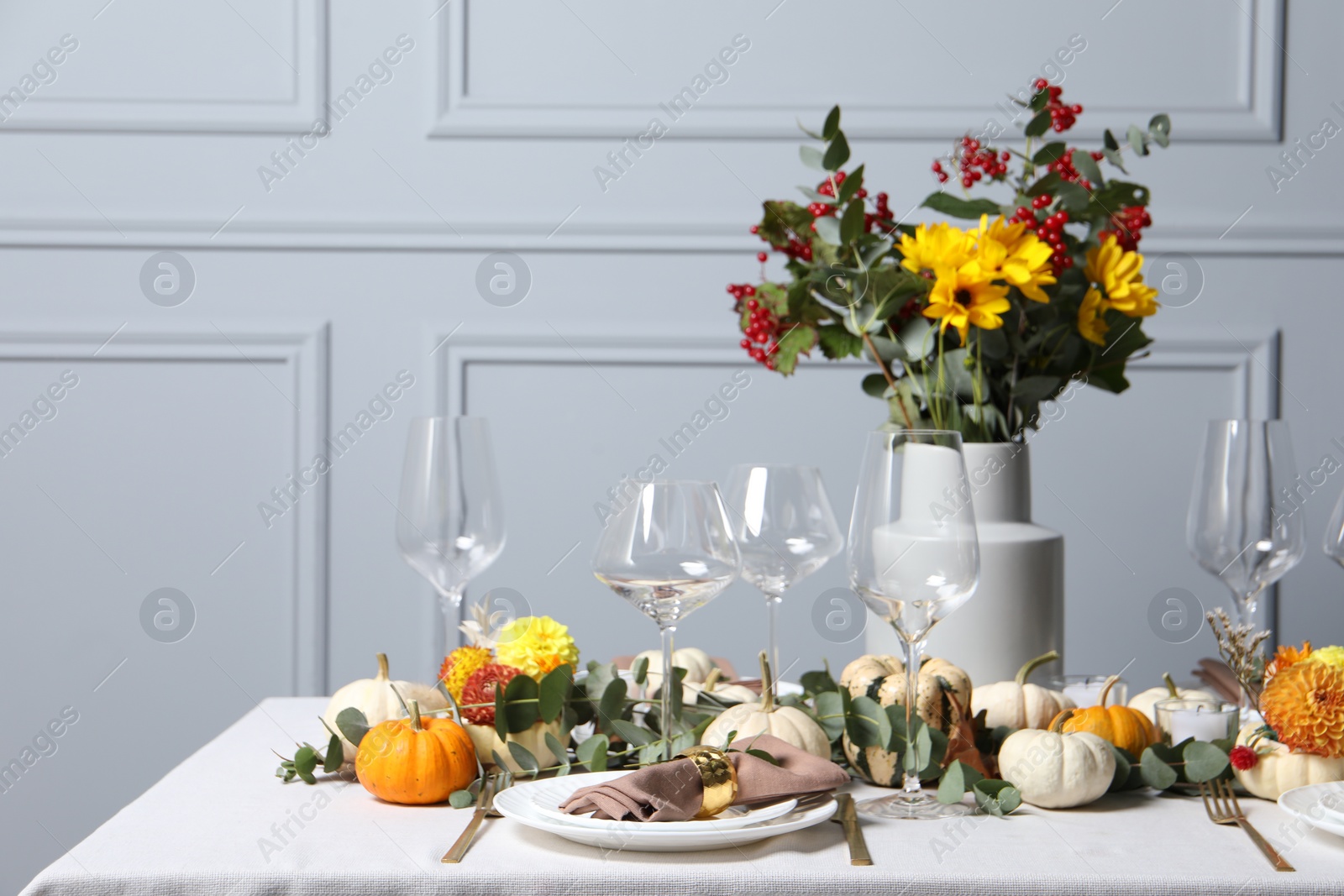 Photo of Beautiful autumn table setting with bouquet indoors. Plates, cutlery, glasses and floral decor