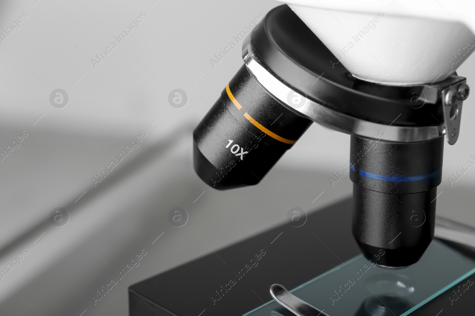 Photo of Modern medical microscope with glass slide on blurred background, closeup. Space for text