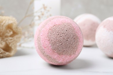 Photo of Pink bath bomb on white table, closeup