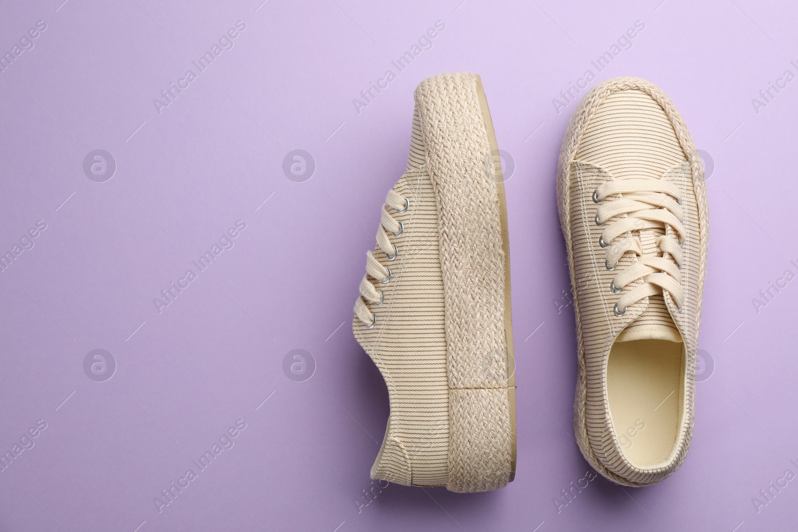 Photo of Pair of stylish comfortable shoes on lilac background, flat lay. Space for text