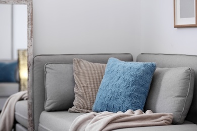 Photo of Different soft pillows on sofa in room. Interior element