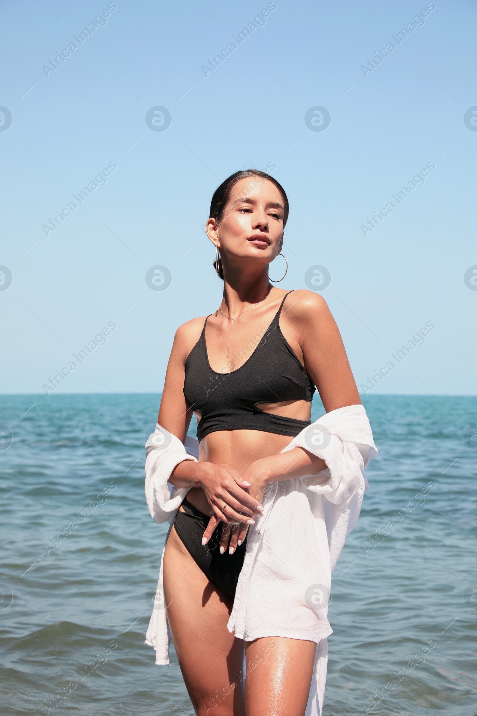 Photo of Beautiful young woman in stylish bikini near sea