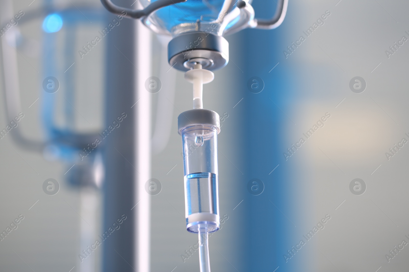 Photo of IV drip chamber against blurred light background