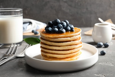 Photo of Plate with pancakes and berries on table