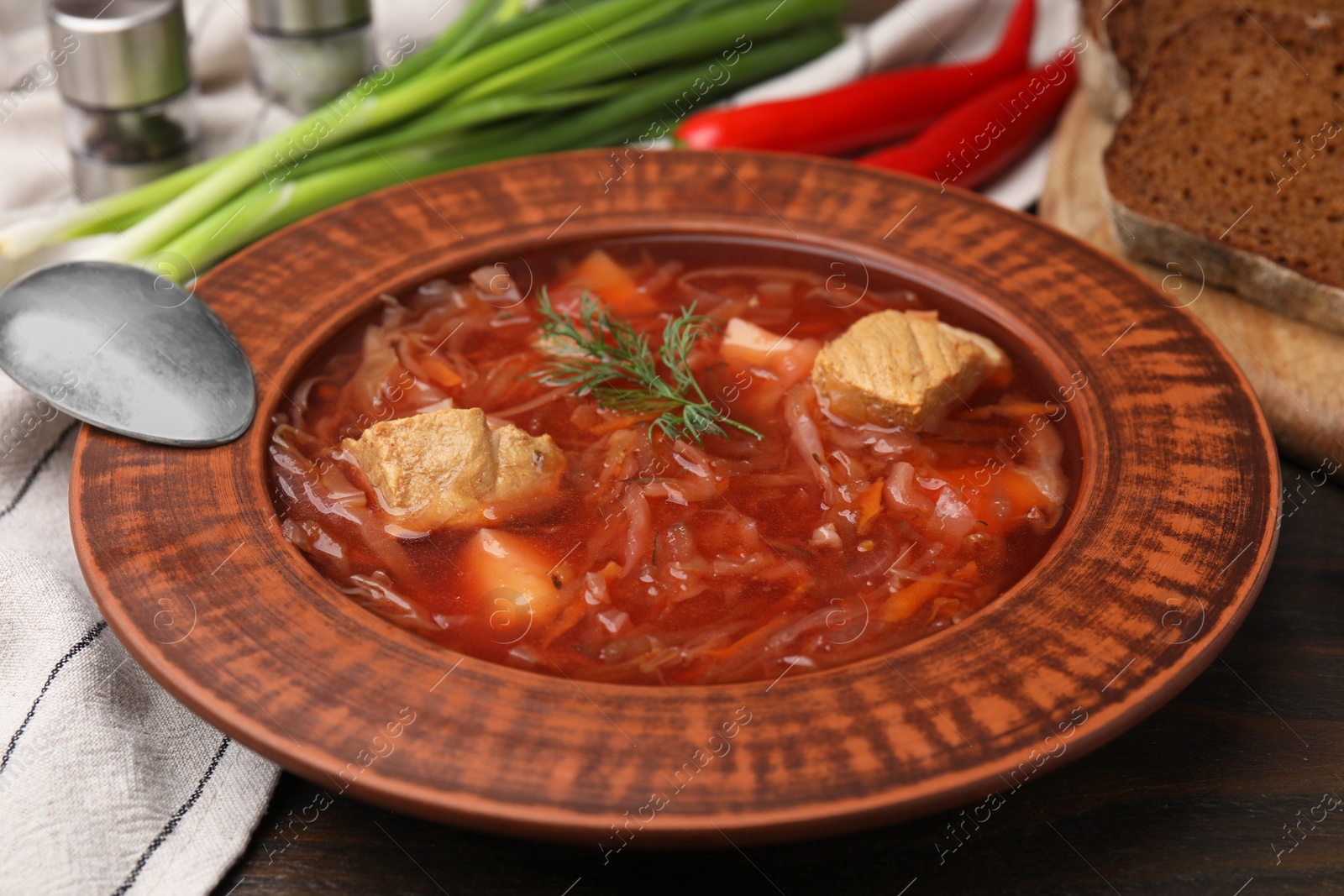 Photo of Bowl of delicious borscht on table, closeup.