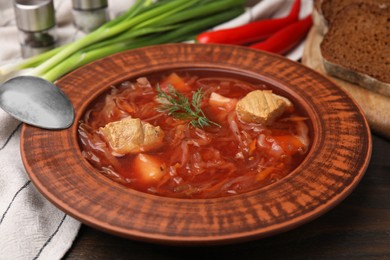 Bowl of delicious borscht on table, closeup.