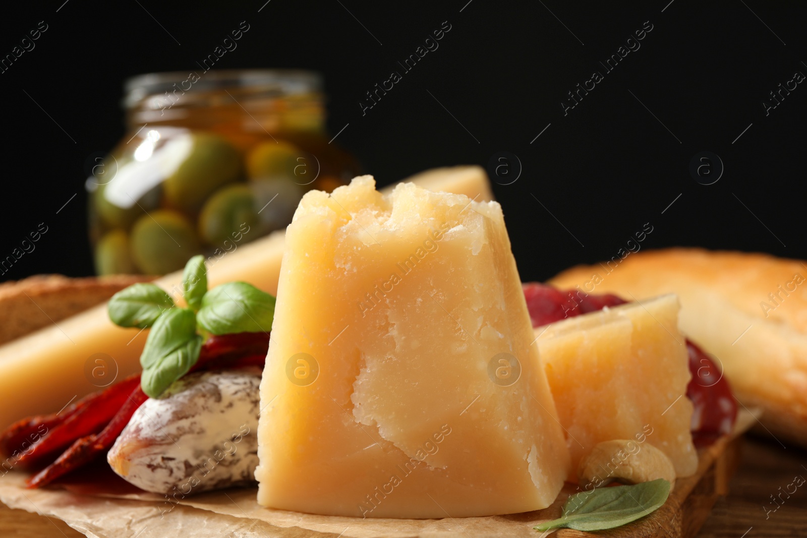 Photo of Delicious parmesan cheese on wooden board, closeup