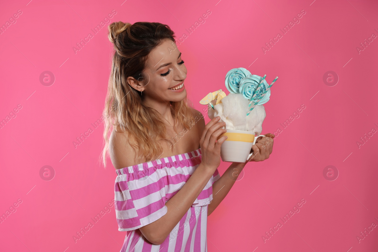 Photo of Portrait of young woman holding cotton candy dessert on color background