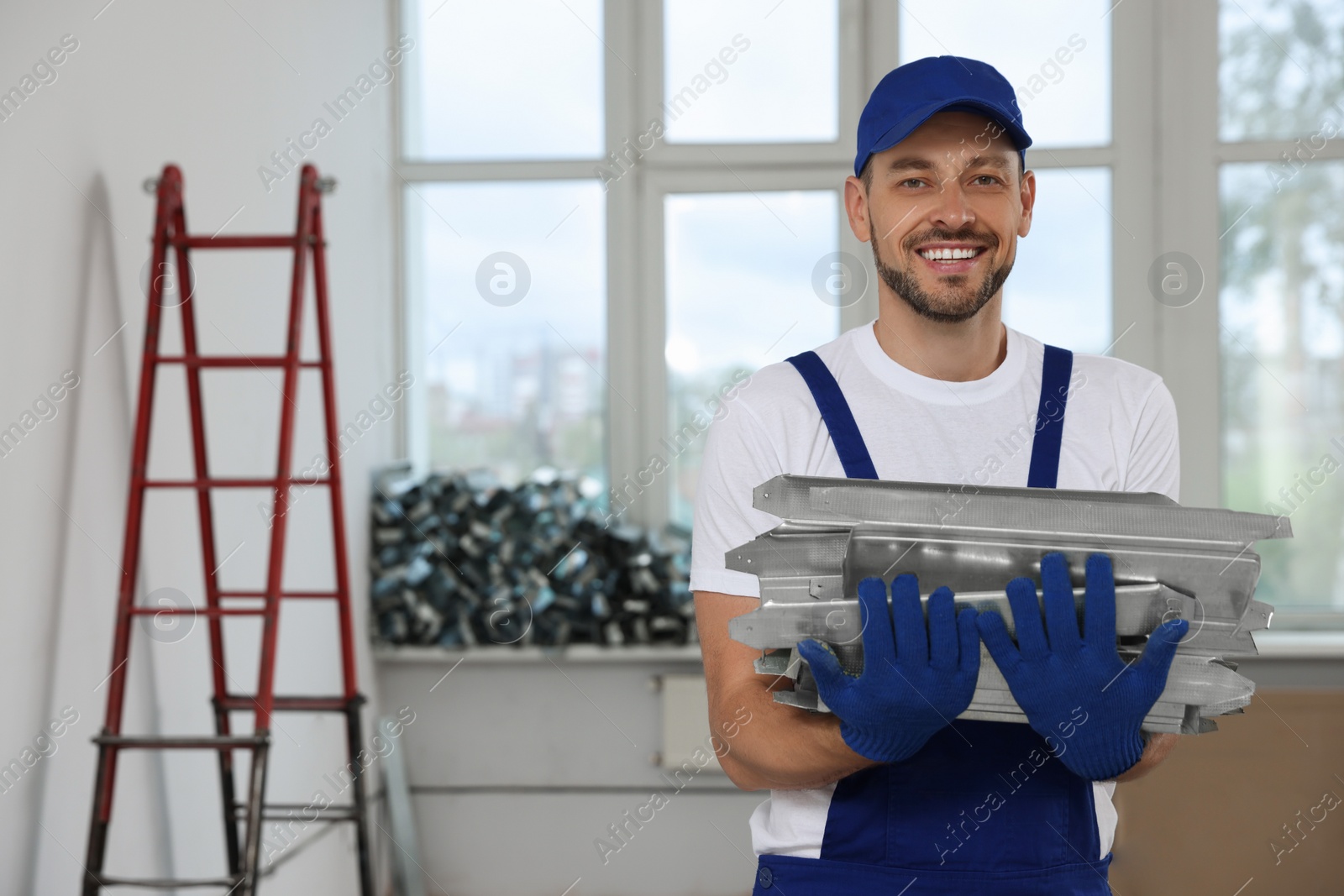 Photo of Construction worker holding used building materials in room prepared for renovation