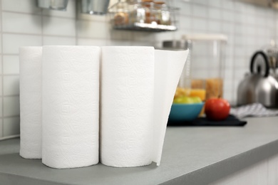 Rolls of paper towels on table in kitchen, space for text