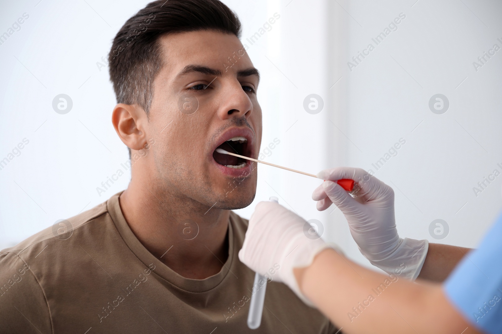 Photo of Doctor taking sample for DNA test from man in clinic