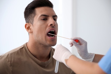 Photo of Doctor taking sample for DNA test from man in clinic