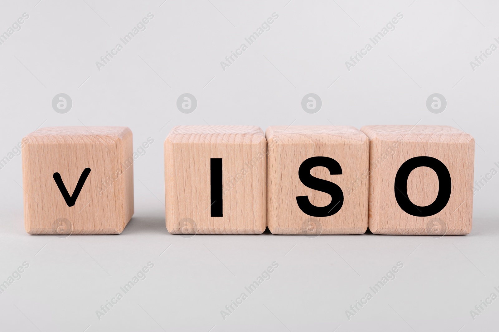 Photo of International Organization for Standardization. Wooden cubes with check mark and abbreviation ISO on light grey background