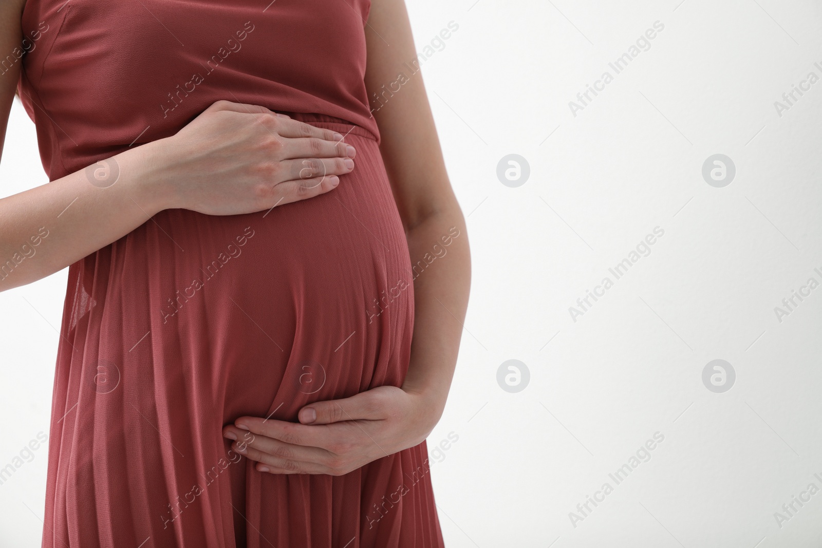 Photo of Young pregnant woman on light background, closeup. Space for text