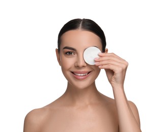 Beautiful woman removing makeup with cotton pad on white background