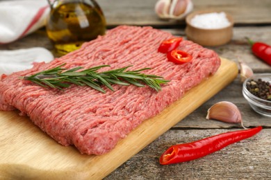 Photo of Raw fresh minced meat and ingredients on wooden table, closeup