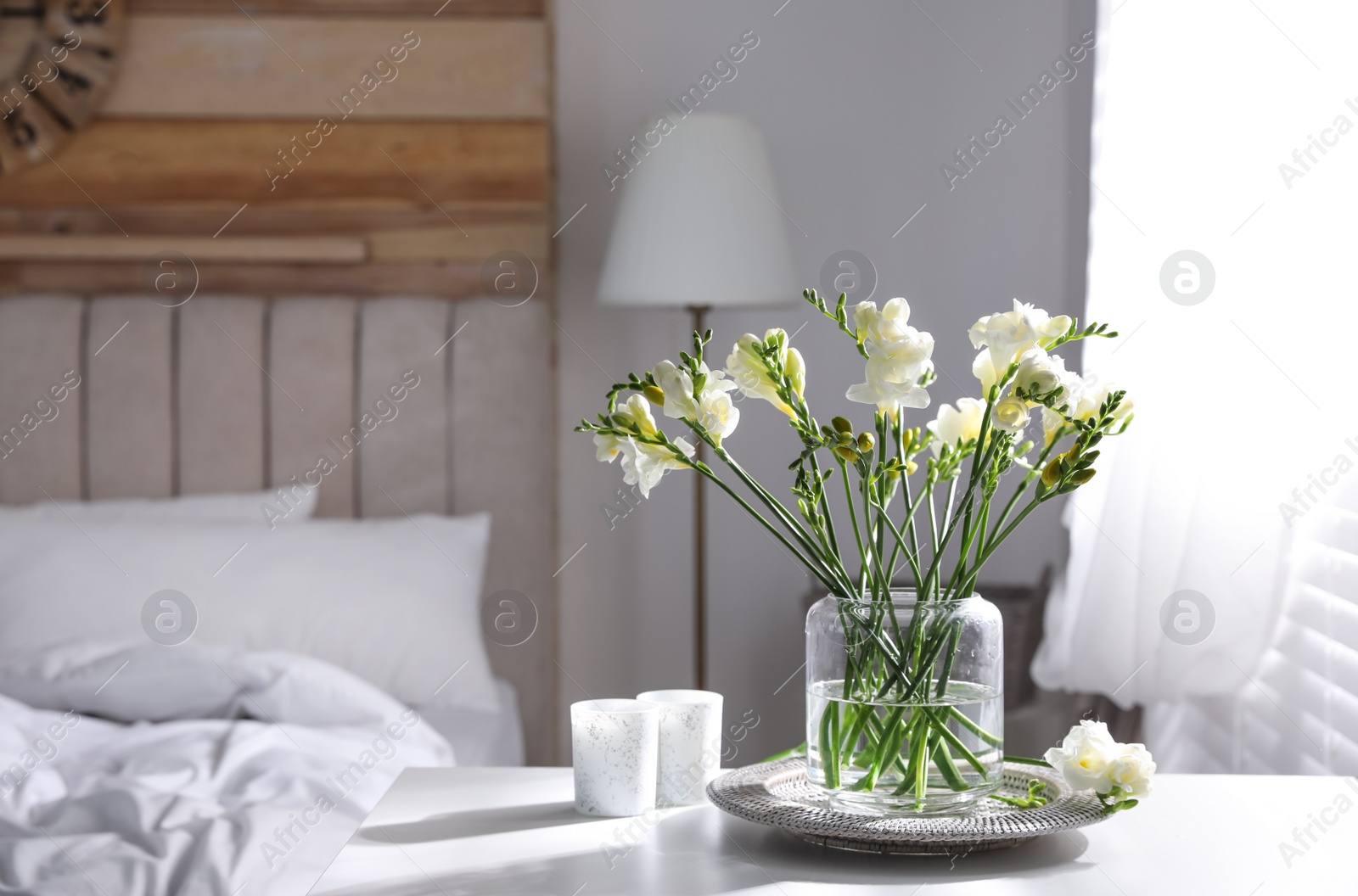 Photo of Beautiful spring freesia flowers on table in bedroom