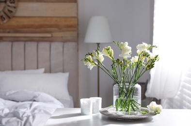 Photo of Beautiful spring freesia flowers on table in bedroom