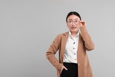 Photo of Portrait of smiling businesswoman on grey background. Space for text