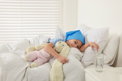 Photo of Childhood cancer. Girl resting with toy bunny in hospital