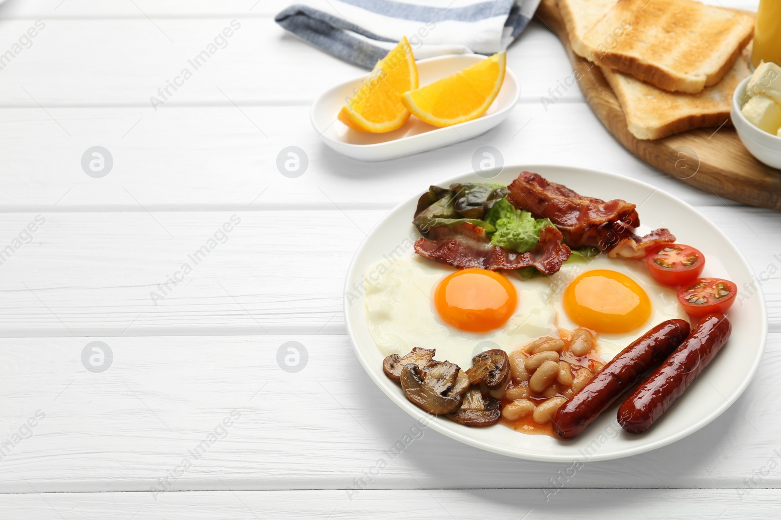 Photo of Delicious breakfast with sunny side up eggs on white wooden table. Space for text