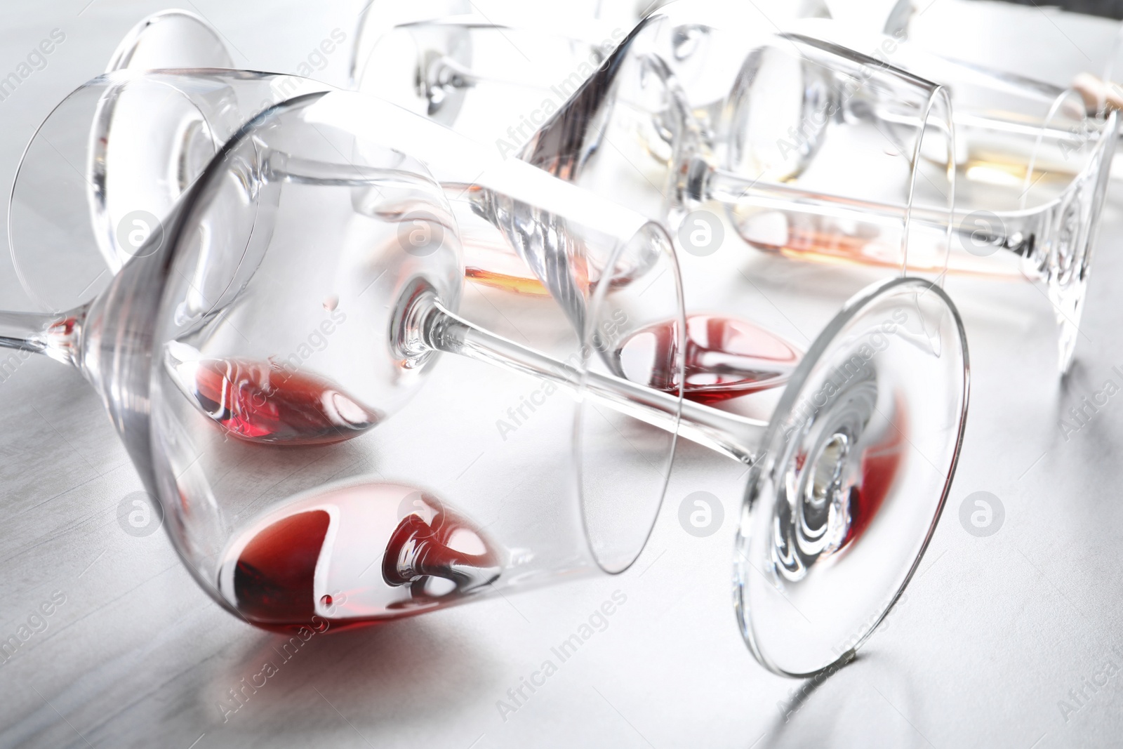 Photo of Different glasses with wine on light background, closeup