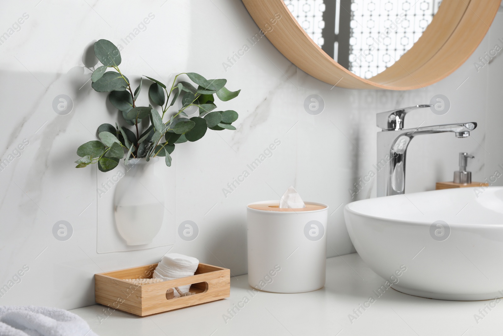 Photo of Silicone vase with eucalyptus branches on white marble wall over countertop in stylish bathroom