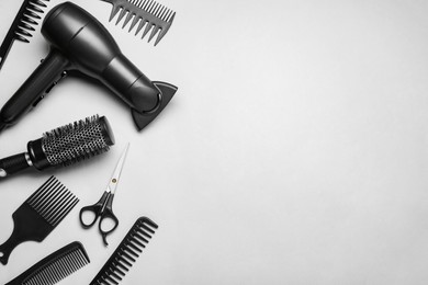 Photo of Flat lay compositionprofessional hairdresser tools on white background, space for text