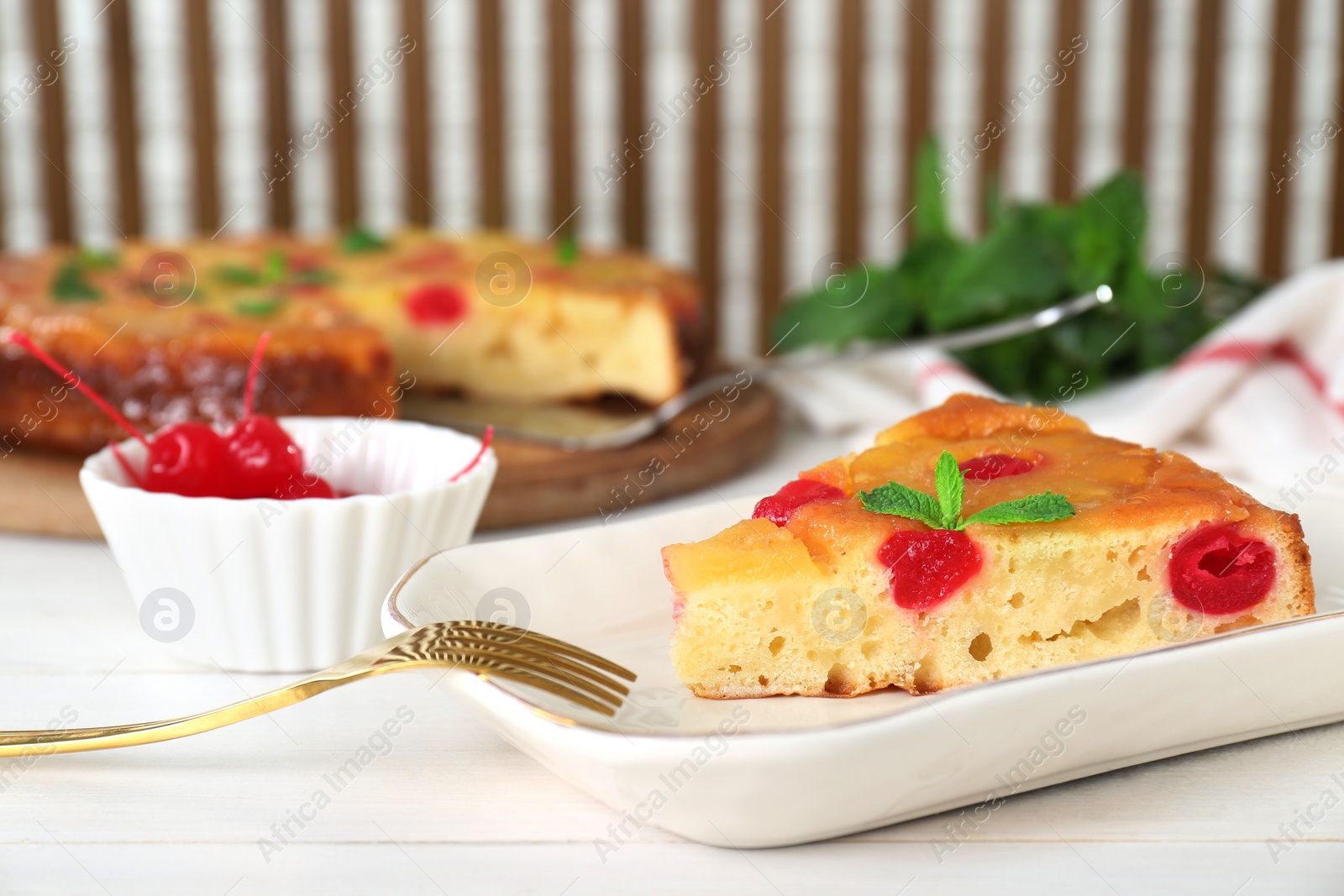 Photo of Piece of delicious pineapple pie with cherry and mint on white wooden table, closeup