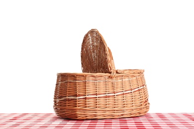 Photo of Empty picnic basket on checkered tablecloth against white background