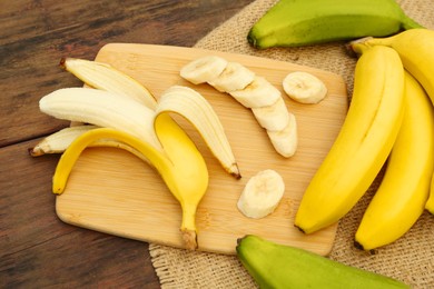 Photo of Whole and cut bananas on wooden table