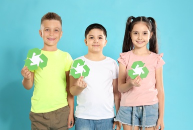 Children with recycling symbols on blue background