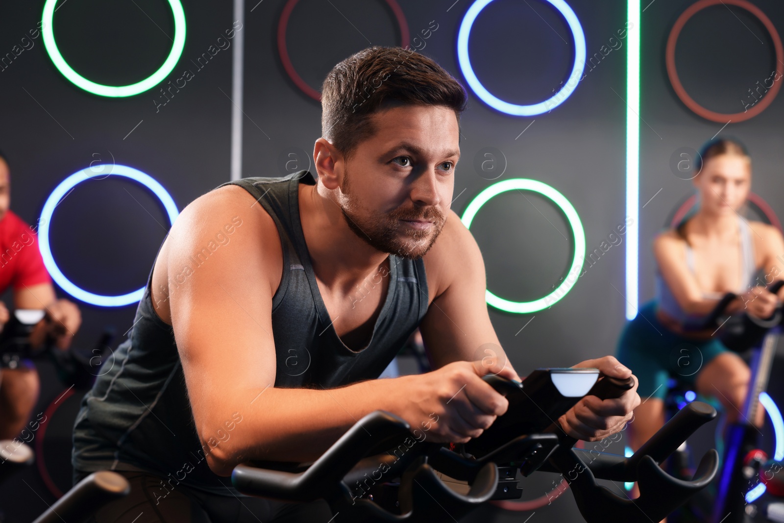 Photo of Man training on exercise bike in fitness club