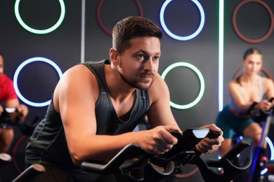 Man training on exercise bike in fitness club