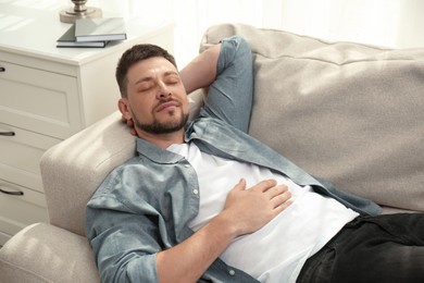 Photo of Handsome man sleeping on sofa at home