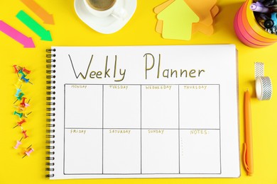 Photo of Flat lay composition of notebook with weekly plan on yellow background