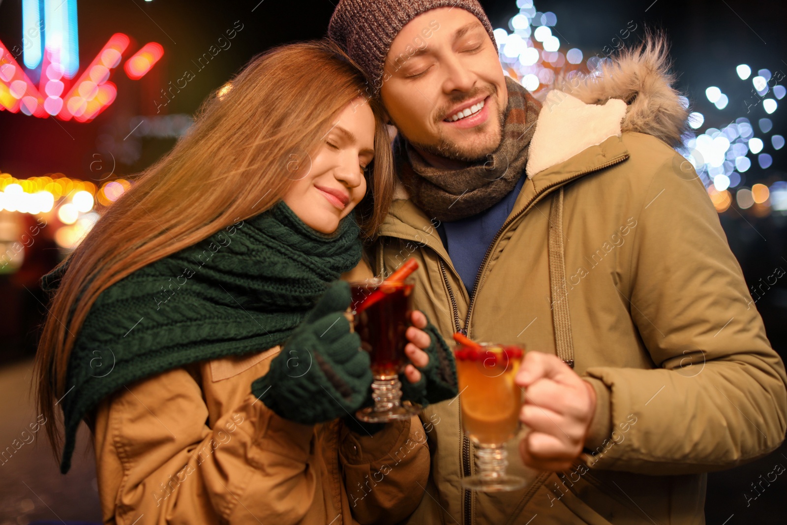 Photo of Happy couple with mulled wine at winter fair