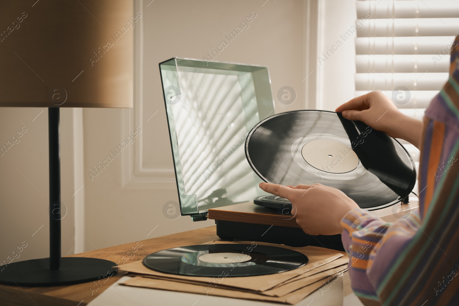 Photo of Young woman using turntable at home, closeup