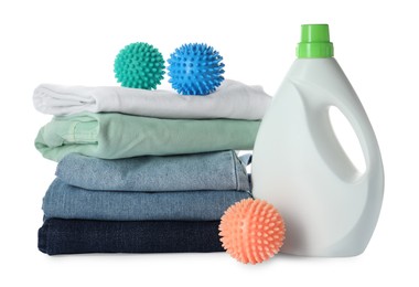 Color dryer balls, laundry detergent and stacked clean clothes on white background