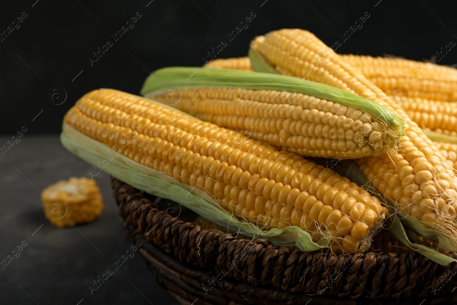 Photo of Basket with tasty sweet corn cobs, closeup